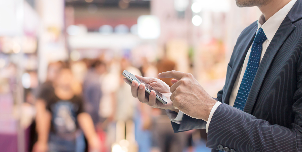 High-density wireless design example: businesspeople using a phone at trade conference